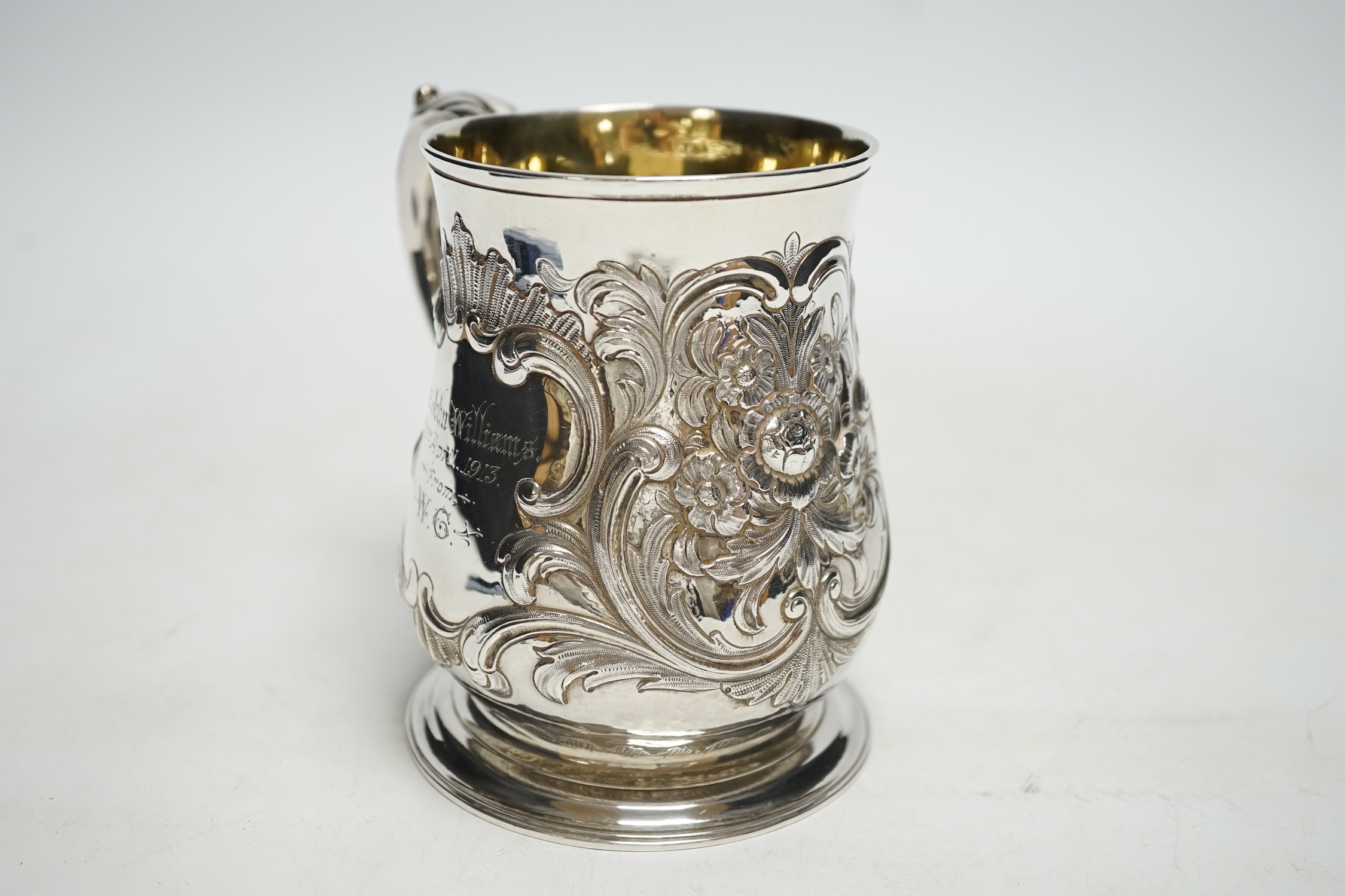 A George II silver pint mug, by John Broughton?, London, 1746, with later embossed decoration and later engraved inscription, 11.8cm, 10.7oz.